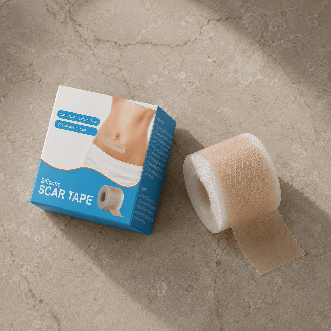 Blaue Verpackung mit der Aufschrift „Silicone Scar Tape" neben einer aufgerollten Silikonrolle auf hellem Steinuntergrund.
